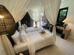 Lotus Luxury Villa Seminyak في سمينياك: غرفة نوم بسريرين ونافذة كبيرة