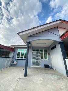 a white house with a garage with a door at 2 Bedroom house with Coway, all room air-cond, WIFI, Nettflix in Kampung Gurun