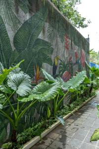 una pared con un mural de plantas y aves en Bukit Jaya Residence & Apartment Semarang, en Semarang