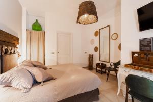 a bedroom with a bed and a desk and a television at Oppure - Masseria Moderna in Polignano a Mare