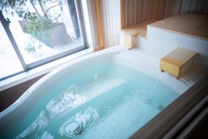 een badkuip in een kamer met een raam bij Otaru Asari Classe Hotel in Otaru +158 foto's