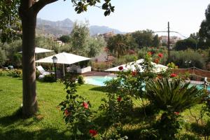 a garden with a swimming pool and some flowers at Avocado B&B Beyond in Giardini Naxos