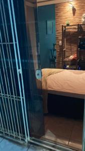 een kamer met een bed en een glazen deur bij Studio montany in Rio das Ostras