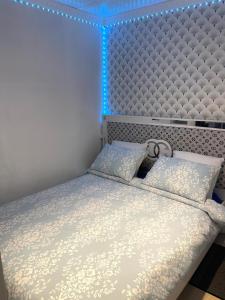 a bedroom with a bed with a blue light at Jolie petite maison avec un grand jardin in Montmagny