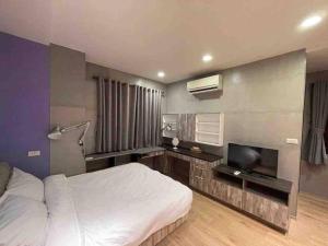 a bedroom with a bed and a flat screen tv at FengJia Pleasure Life 2 in Taichung