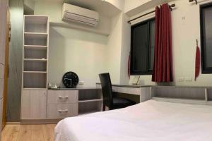 a bedroom with a bed and a desk and a chair at FengJia Pleasure Life 2 in Taichung
