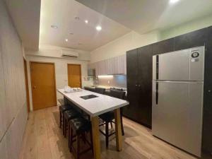 a kitchen with a refrigerator and a table with chairs at FengJia Pleasure Life 2 in Taichung