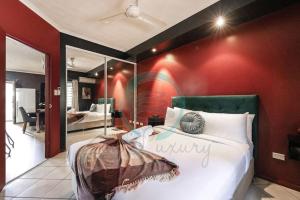 a bedroom with a large bed with a red wall at ZEN MARKETS - Boutique 1-BR Apt Near Parap Markets in Paraparap