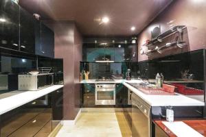 a large kitchen with black cabinets and a sink at ZEN MARKETS - Boutique 1-BR Apt Near Parap Markets in Paraparap +16 photos