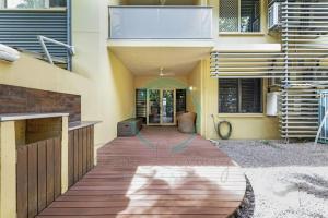 a house with a wooden walkway in a yard at ZEN MARKETS - Boutique 1-BR Apt Near Parap Markets in Paraparap