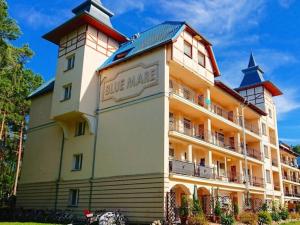 a large building with a sign on the side of it at Comfortable apartment, summer outdoor swimming pool, large garden, uk cin in Łukęcin