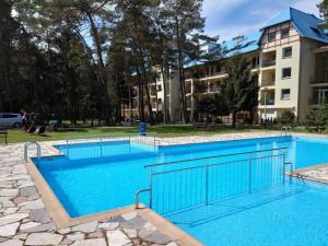 a large blue swimming pool in front of a building at Comfortable apartment, summer outdoor swimming pool, large garden, uk cin in Łukęcin