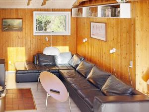 a living room with a leather couch and a table at 6 person holiday home in N rre Nebel in Lønne Hede