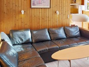 a leather couch in a living room with a table at 6 person holiday home in N rre Nebel in Lønne Hede