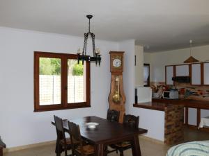 a dining room with a table and a grandfather clock at Maison Calme avec Jardin, Proche Lac et Centre, Animaux Bienvenus, Ménage Inclus - FR-1-319-408 in Sanguinet
