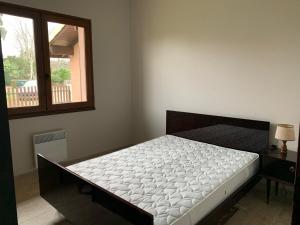 un letto in una stanza con una finestra di Maison Calme avec Jardin, Proche Lac et Centre, Animaux Bienvenus, Ménage Inclus - FR-1-319-408 a Sanguinet