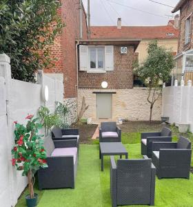 une cour avec des chaises noires et une cour avec une maison dans l'établissement Jolie petite maison avec un grand jardin, à Montmagny