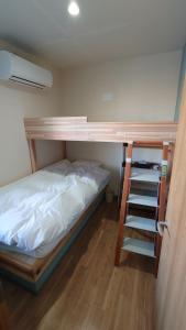 1 dormitorio con litera y escalera en 宿 inn TEK-TEK en Sanuki