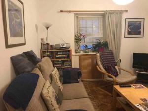 a living room with a couch and a table at Cosy cottage flat in Inveraray