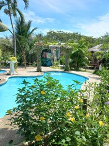 a swimming pool at a resort with a garden at Hotel Bambú in Canoa