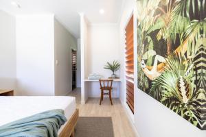 Un dormitorio con una cama con un cuadro en la pared. en The Retreat, en South Mission Beach 21 fotos más