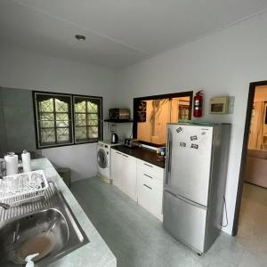 a kitchen with a sink and a refrigerator at Baan Sawainam in Ko Tao