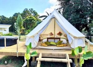 ein weißes Zelt mit einem Bett auf einer Holzterrasse in der Unterkunft Kalika Balayan in Balayan