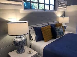 a bedroom with a bed and a lamp on a table at Hamptons In Rye Blue Cottage 3 Mins from Hot Springs! in Rye
