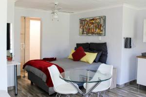 1 dormitorio con cama y mesa de cristal en 4 on Verbena en Boksburg