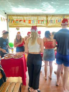 a group of people wearing santa hats standing around a table at Orchid Guesthouse in Phu Quoc