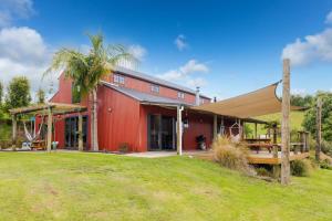 a red barn with a palm tree in front of it at Nadarra Hideaway in Otorohanga
