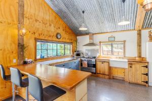 a kitchen with wooden walls and a large wooden table at Nadarra Hideaway in Otorohanga