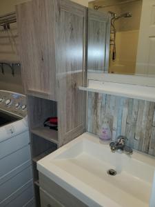 a white sink in a kitchen with a mirror at Saratoga beach cottage, private non-resort, easy beach access, 35mins Mt Washington in Oyster Bay