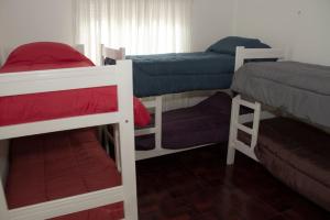 a room with three bunk beds in a room at Guanaco Hostel in Puerto Madryn