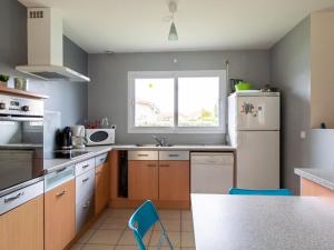 une cuisine avec un réfrigérateur blanc et une fenêtre dans l'établissement Grande maison familiale 4 chambres, 140m², proche forêt, terrasse et jardin clos, Biscarrosse - FR-1-521-22, à Biscarrosse