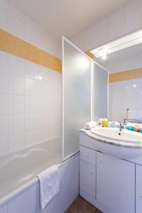 Baño blanco con bañera y lavamanos en Lagrange Vacances L'Orée des Cîmes en Les Angles