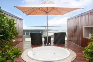 a bath tub on a deck with an umbrella at InterContinental Qingdao, an IHG Hotel - Inside the Olympic Sailing Center in Qingdao