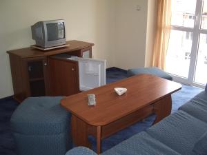 ein Wohnzimmer mit Fernseher und Tisch und Stühlen in der Unterkunft Vanessa Family Hotel in Rawda + 15 Fotos