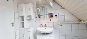 a white bathroom with a sink and a mirror at FeWo-1-OG-links in Böhl