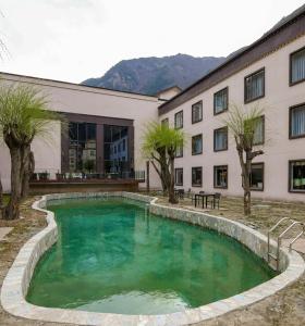 a swimming pool in front of a building at Qianhe International Hotel in Jiuzhaigou
