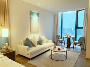 sala de estar con sofá y mesa en HB Serviced Apartment - Alacarte Hạ Long, en Ha Long