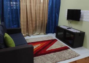 ein Wohnzimmer mit einem Sofa und einem Tisch in der Unterkunft Homestay Asfa&Wazif in Arau
