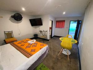 sypialnia z łóżkiem i żółtym krzesłem w obiekcie Aeropark Residencial (B&B) w mieście Maputo