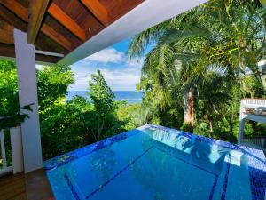 a swimming pool with a view of the ocean at Top Ridge Views - 1 Bedroom in Sandy Bay