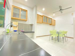 a kitchen with a sink and a table with chairs at Taman Saikat IPOH comfortable HomeStay 12 Pax in Ipoh