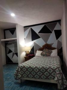 una camera con un letto con una parete in bianco e nero di Casa Yemaya a Santa María Tonantzintla