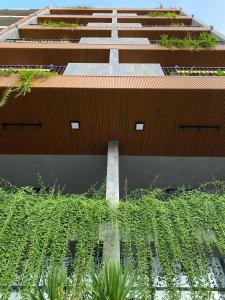 a building with a lot of plants in front of it at LAGOM APARTMENT AND HOTEL in Da Nang