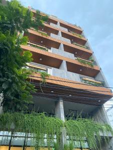 un edificio con plantas a su lado en LAGOM APARTMENT AND HOTEL en Da Nang