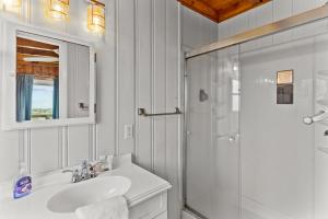 a white bathroom with a sink and a shower at Dock Holiday in Oak Island +23 photos