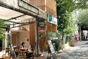 a woman sitting at a table outside of a restaurant at COCO Nakameguro 202 in Tokyo
